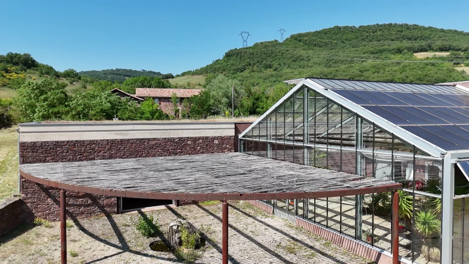 Verrière, pergola et maison historique à l’arrière-plan